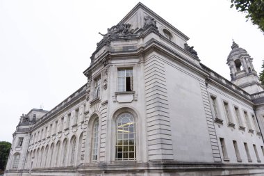 CARDIFF, İngiltere - 8 AĞUSTOS 2025 - Görkemli Cardiff Belediye Binası 'nın manzarası, karmaşık heykelleri, Portland taş cephesi ve bulutlu bir gökyüzünün altındaki belirgin saat kulesi