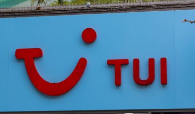 CARDIFF, İngiltere - 8 AĞUSTOS 2025 - Galler, Cardiff 'te bir TUI mağazasının açık mavi duvarında kırmızı TUI logosu