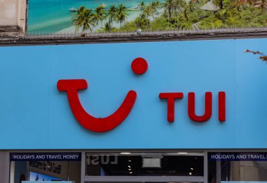 CARDIFF, İngiltere - 8 AĞUSTOS 2025 - Cardiff şehir merkezinde, üzerinde tropik bir görüntü olan açık mavi bir duvarda kırmızı TUI logosu