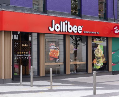 CARDIFF, İngiltere - 8 AĞUSTOS 2025 - Cardiff, Galler 'deki bir Jollibee fast food restoranının dış mekanı, markasını, menülerini ve yemek yiyen bir müşteriyi gösteriyor