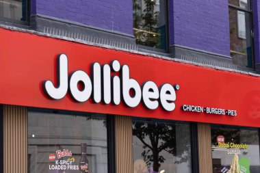 CARDIFF, İngiltere - 8 AĞUSTOS 2025 - Cardiff, Galler 'de kırmızı Jollibee tabelası ve mağaza vitrininde tavuk, hamburger ve turta gibi menü öğeleri gösteriliyor
