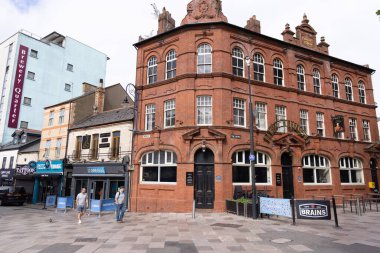 CARDIFF, İngiltere - 8 AĞUSTOS 2025 - Galler 'in Cardiff şehrindeki geleneksel kırmızı tuğlalı bar, Brains bira markasını gösteriyor