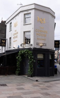 CARDIFF, İngiltere - 8 AĞUSTOS 2025 - The Corner House Bar 'ın dış mekanı ve tabelaları ve sokak manzarasıyla Galler' in Cardiff kentinde akşam yemeği