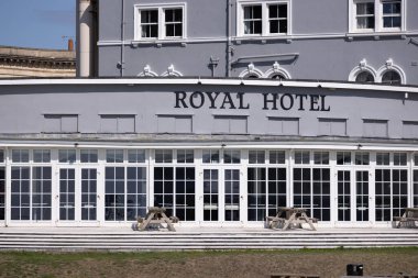 WESTON, UK - 8 AĞUSTOS 2025 - İngiltere 'nin Weston Super Mare şehrinde önünde büyük pencereleri ve piknik masaları olan zarif görünüşlü Royal Hotel