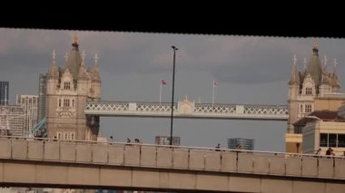 LONDON, UK - 5 AĞUSTOS 2025 - İngiliz bayrakları sallayan ve Londra, İngiltere 'de bir köprüde yürüyen insanlar olan Tower Bridge