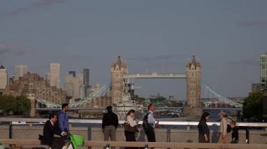 LONDON, UK - 5 AĞUSTOS 2025 Kule Köprüsü ve Londra silueti arka planda yürüyen ve bisiklet süren insanlar
