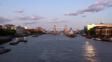 LONDON, UK - 5 AĞUSTOS 2025 - Tower Bridge, Thames Nehri 'ni teknelerle ve HMS Belfast' ı günbatımında yansıtıyor, Londra, İngiltere