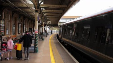 LONDON, İngiltere - 8 AĞUSTOS 2025 - Anne ve çocuklar Londra, İngiltere 'de bir tren istasyonunda yürüyorlar.