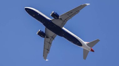 LONDON, UK - 5 AĞUSTOS 2025 - Londra üzerinde yükselen yolcu uçağı, canlı mavi gökyüzüne karşı onun altında bir görünüm sunuyor