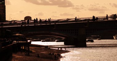 LONDON, İngiltere - 5 AĞUSTOS 2025 - Londra 'daki Millennium Köprüsü' nde gün batımında yürüyen turist siluetleri