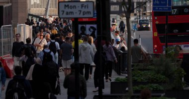 LONDON, İngiltere - 5 AĞUSTOS 2025 - Turistler ve vatandaşlar öğleden sonra Londra kaldırımında kırmızı çift katlı bir otobüsün yanında yürüyorlar