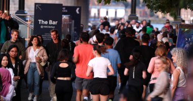 LONDON, İngiltere - 5 AĞUSTOS 2025 - Turistler ve koşucular HMS Belfast, Londra 'da bir yaz akşamının tadını çıkarıyorlar