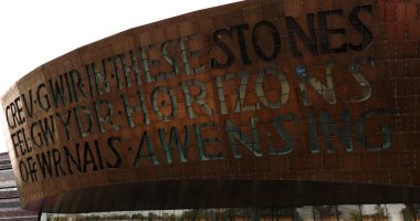 CARDIFF, İngiltere - 8 AĞUSTOS 2025 - Cardiff 'teki Galler Milenyum Merkezi bu taşlardaki yaratıcılığı kutlayan Galler yazıtlarını gösteriyor, ufuk çizgileri şarkı söylüyor