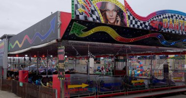 CARDIFF, İngiltere - 8 AĞUSTOS 2025 - Renkli ışıklı ve kareli bayraklı çarpışan arabalar Cardiff, Galler 'deki bir lunaparkta müşterileri bekliyor