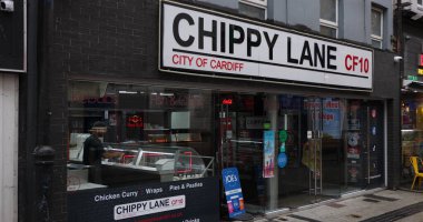 CARDIFF, İngiltere - 8 Ağustos 2025 - Geleneksel İngiliz paket servisi, Chippy Lane, Cardiff, Galler 'de, balık ve cips ve diğer fast food seçenekleri sunuyor