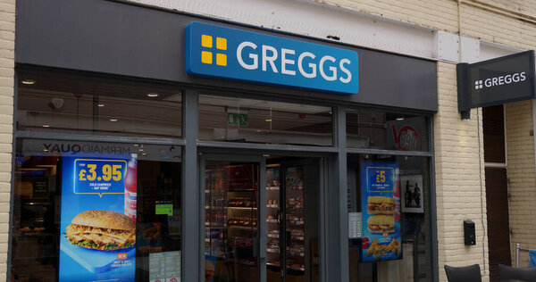 CARDIFF, UK - AUGUST 8, 2025 - Greggs plc, a popular British bakery chain, displays meal deals and promotions at its Cardiff storefront