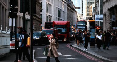 LONDON, UK - 5 AĞUSTOS 2025 - Londra 'da kırmızı çift katlı otobüsler, arabalar ve geçen kamyonlarla kalabalık bir caddeden geçen insanlar