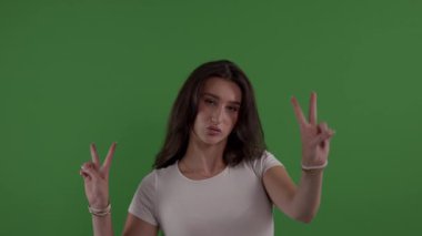 İki eli de krom anahtarda barış sembolü gösteren genç bir kadın.