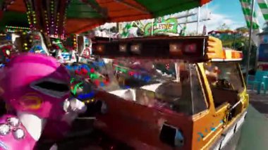 LUXEMBURG, EUROPE - 1 Eylül 2025 - Pembe Power Ranger, güneşli bir günde Lüksemburg 'daki ünlü Schueberfouer lunaparkında bir atlıkarınca sürüyor