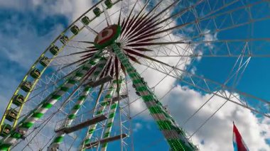 LUXEMBURG, EUROPE - 1 Eylül 2025 - Lüksemburg 'daki en büyük lunapark olan Schueberfouer' deki bulutlarla mavi gökyüzü altında dönen dönme dolap