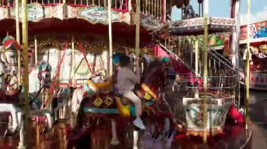 LUXEMBURG, EUROPE - 1 Eylül 2025 - Genç çocuk Lüksemburg 'daki Schueberfouer lunaparkında geleneksel bir atlıkarıncaya binerken eğleniyor