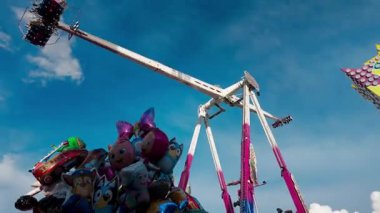 LUXEMBURG, EUROPE - 1 Eylül 2025 - Lüksemburg 'daki en büyük lunapark olan Schueberfouer' de mavi gökyüzü altında süzülen büyük renkli balonlar ve heyecan verici geziler