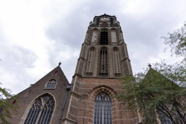 ROTTERDAM, NETHERLANDS - 13 Eylül 2025 Rotterdam 'daki bulutlu gökyüzüne doğru yükselen Grote Kerk. ROTTERDAM, NETHERLANDS - 13 Eylül 2025 -