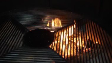Izgara yap. Alevli ızgara ızgara. Restoran mutfağında büyük ızgara çeviriyor. Izgaranın altından yanan bir ateş görülebilir. Barbekü.