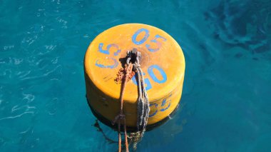 Yaz, deniz, şeffaf mavi sularda turuncu şamandıralar yüzer. Yüksek kalite fotoğraf