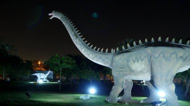 Dubai Garden Glow Park 'taki Dinozor Parkı, gece aydınlandı. Bir sürü farklı dinozor, canlı görünüyorlar. Yüksek kalite fotoğraf