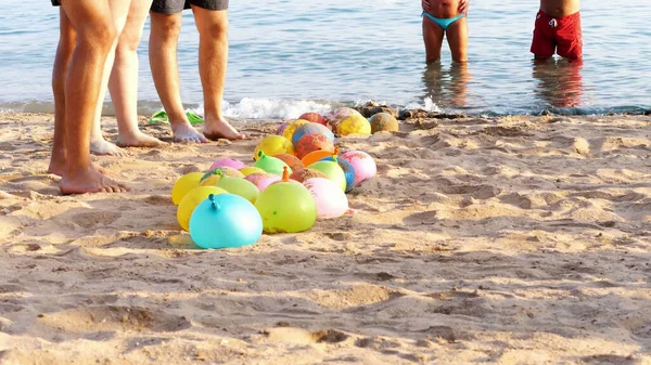 on the beach, on the sand are balloons filled with water instead of air. people having a rest playing fun games on the beach. High quality photo