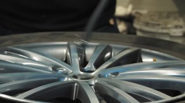  Lastik. Araba servisi. Tekerlek tamircisi tekerleği, araba kenarını, çamurdan ve tozdan temizleyerek hazırlıyor. Yüksek kalite 4k görüntü