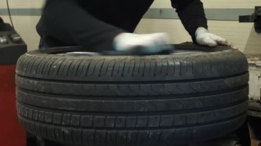  Lastik. Araba servisi. Tekerlek tamircisi tekerleği, araba kenarını, çamurdan ve tozdan temizleyerek hazırlıyor. Yüksek kalite 4k görüntü