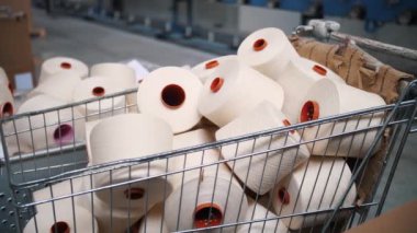 Bir sepetteki iplik maşaları. İplik yapma süreci. Tekstil fabrikası ekipmanı. Dönen yapım. İplik üretimi. Tekstil fabrikası. Fabrika makineleri makaraları ya da bobinleri geri sarıyor