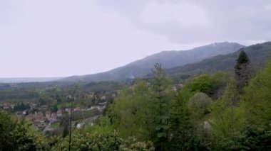 İtalyan dağ köyü. Alpler. bahar manzarası. Kırmızı çatı kiremitleri altındaki görkemli kırsal evler. İtalyan mimarisi ve doğası