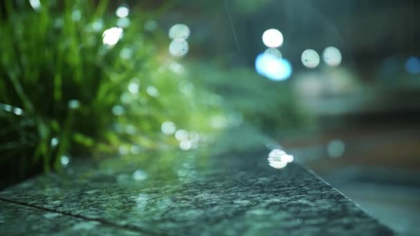 夜に雨が降る 光の雨 降雨量の閉鎖 プドルだ 水のプドル 水没した道路 街の歩道に光の反射と水たまり 夜の街 — ストック動画
