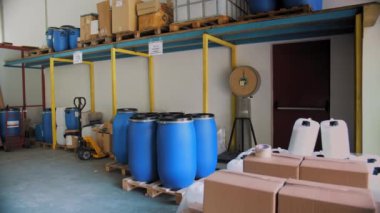 Production of cosmetics. Cosmetic manufacturing process. Automatic packaging of cosmetics. Cosmetic factory. Warehouse of chemical products. Packaging. Empty cartons. Large plastic containers. Barrels