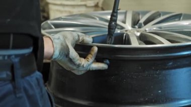 Tekerlek jant hazırlığı. Lastik servisi. Araba tekerleği. Modern ekipmanlarda lastik servisi. Tamirci, profesyonel ekipman kullanarak lastiği jantından çıkarıyor.