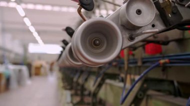 Tekstil fabrikası. Dönen yapım. İplik üretimi. İplik yapma süreci. Tekstil fabrikası ekipmanı. Fabrika makineleri makaraları ya da pamuklu ya da yün ipliklerle bobinleri geri sarıyor. 