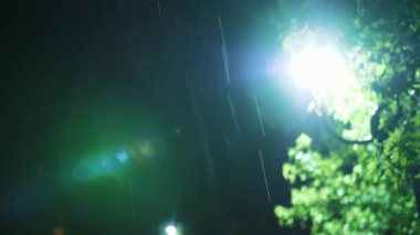 Sokak lambası. Yağmur damlası. Geceleyin yağmur. Yağmur. Gece yağmur yağacak. Hafif yağmur. Yağmura yakın çekim. Su birikintisi Su birikintisi. Sualtı yolu. Şehir kaldırımında ışık yansıyan su birikintisi. Gece