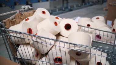 Bir sepetteki iplik maşaları. İplik yapma süreci. Tekstil fabrikası ekipmanı. Dönen yapım. İplik üretimi. Tekstil fabrikası. Fabrika makineleri makaraları ya da bobinleri geri sarıyor