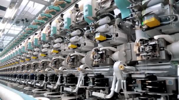 繊維工場だ スピニング生産 糸の生産 糸の製造工程だ 繊維工場設備 工場機械は リールまたはボビンを綿または毛糸で巻き戻しています — ストック動画