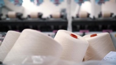 İplik ipliklerinin yakın çekim makaraları. Dönen yapım. Tekstil fabrikası. İplik yapma süreci. İplik üretimi. Tekstil fabrikası ekipmanı. Fabrika makineleri makaraları ya da pamuklu bobinleri geri sarıyor