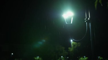 Sokak lambası. Yağmur damlası. Geceleyin yağmur. Yağmur. Gece yağmur yağacak. Hafif yağmur. Yağmura yakın çekim. Su birikintisi Su birikintisi. Sualtı yolu. Şehir kaldırımında ışık yansıyan su birikintisi. Gece