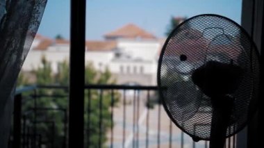  Havalandırma rüzgarı esiyor, sağa sola dönüyor. Yakın plan. Elektrikli vantilatör odayı soğutuyor. Elektrikli soğutma pervanesi yaz günü apartmanda çalışıyor.. 