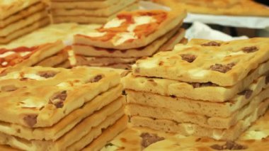 pizza. Sokak yemeği. Yakın plan. Taze pişmiş pizza. Peynirli ve zeytinli dilimlenmiş hamur hamurlu pizza. Fırın. Puf böreği. Pişirme. Yemek festivali. Açık hava yemekleri. Adil. Sokak pazarı. Mutfak