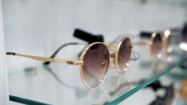 Güneş gözlüğü. Moda gözlüklerinin farklı modelleri olan bir vitrin. Yakın plan. Gözlük. Alışveriş. Perakende mağazasından güneş gözlüğü almak. Optik dükkanı. 