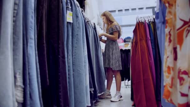 Winkelen Verkoopseizoen Broeken Broeken Jeans Kopen Een Jong Meisje Kiest — Stockvideo