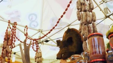 Ev yapımı sosisler. Et. Sokak yemeği. Yakın plan. Salam ve cervelat sosis, pastırma ve diğer et ürünleri. İştah açıcı ve lezzetli. Bir yaban domuzu kafası, vitrin dekorasyonu için.