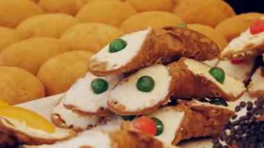 Şekerleme. Fırın ürünleri. Tatlı hamur işleri. Yakın plan. Meşhur Sicilya Cannoli 'si, şekerli İtalyan bisküvileri, kremalı donutlar ve pudra şekeri. Markette sokak yemeği. Pişirme. 